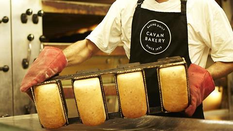 A worker empties out freshly-baked bread tins at The Cavan Bakery's new production site in Walton-on-Thames  3200x1800