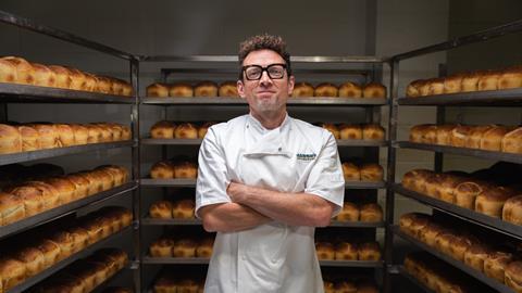 A room full of sourdough loaves with Jason Geary in baker's whites in the middle