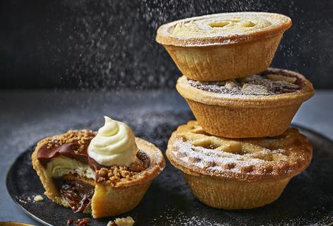 Mince pies stacked on top of each other with a dusting of icing sugar