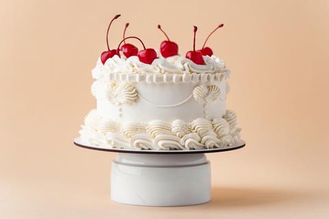 A cake decorated in Lambeth style frosting with cherries on top