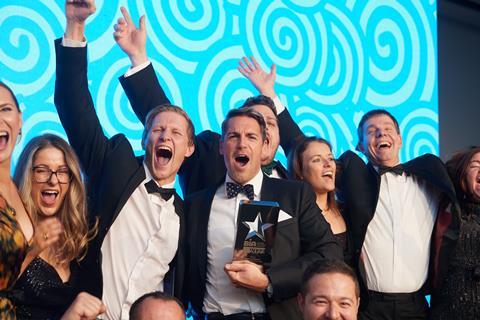 Excited looking people in tuxedos celebrating winning an award