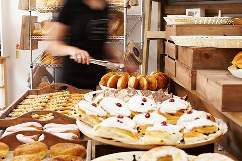 A service staff member moves to pick up a sweet treat for a customer at a Cavan Bakery shop  1404x936