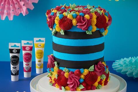 A blue and black cake with colourful swirls of frosting on
