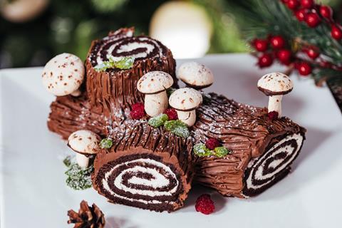 A festive looking yule log with edible sweet mushrooms on top