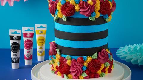 A blue and black cake with colourful swirls of frosting on