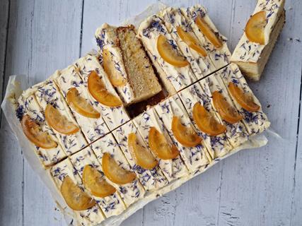 An orange, cardamom and bay tray cake with corn flowers and candied orange on top