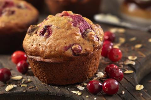 Cranberry muffins with fresh cranberries next to it