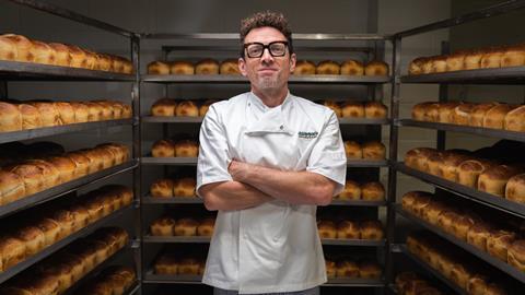 A room full of sourdough loaves with Jason Geary in baker's whites in the middle