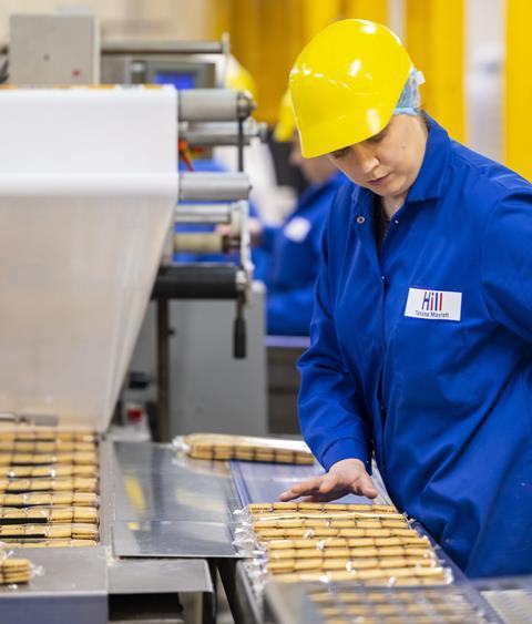 A worker checks packets of custard cream at Hill Biscuits factory  1534x1800