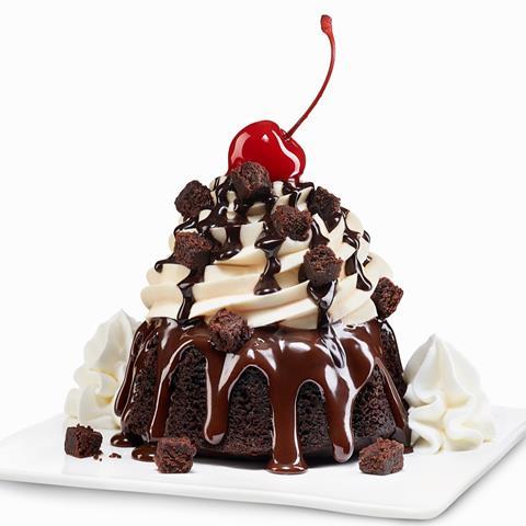 Brownie with cream, chocolate sauce and a cherry on top