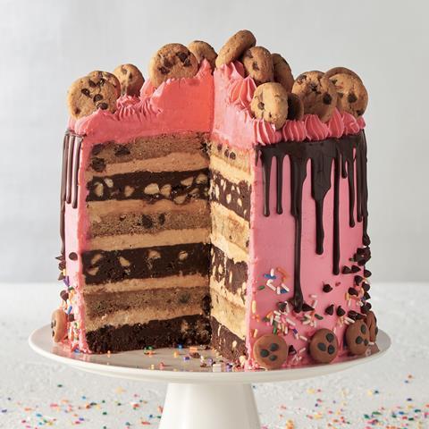 Layered celebration cake decorated with cookies and chocolate drip