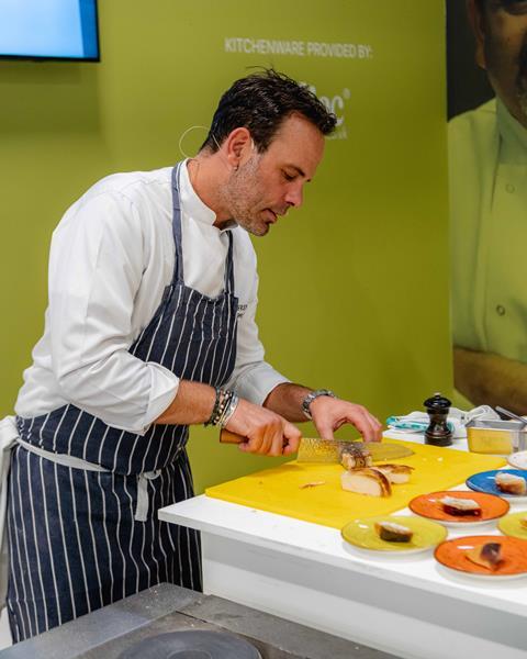 Chef Greg Marchand, owner of the Frenchie restaurant, slices cake during a live demonstration at The Restaurant Show 2023