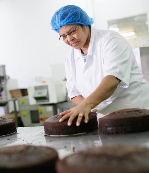 A baker works on a cake line at a Mademoiselle Desserts site  1556x1800