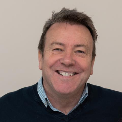 Mike Woods, a smiling man in a blue jumper
