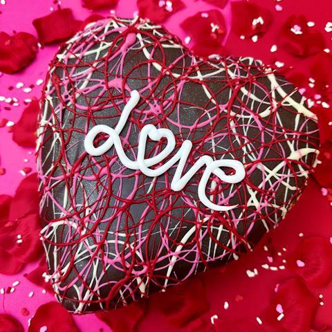 A heart shaped doughnut with love written on top