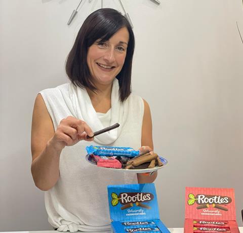 A woman with dark hair in a white top with chocolate covered biscuits