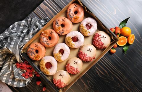 A selection of brightly coloured doughnuts in a box`