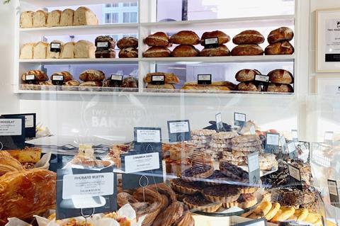 Sourdough loaves and other baked goods on white shelves