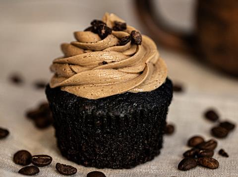A chocolate cupcake with coffee flavoured frosting and coffee beans on top