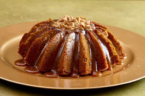 A sticky toffee crown shaped cake on a gold plate