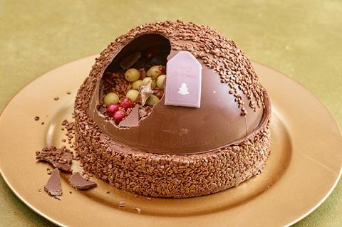 A chocolate cake with smashed chocolate dome on top
