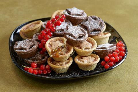 Mini mince pies with stars on top on a black plate