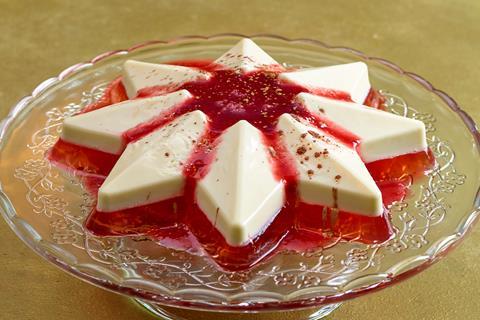 A red and white panna cotta star on glass cake stand