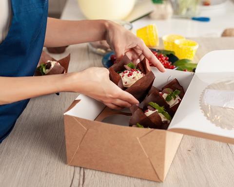 A woman putting festive cupcakes in a box