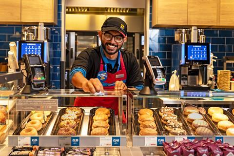 An employee wipes a counter at Greggs' new outlet at Gatwick airport  