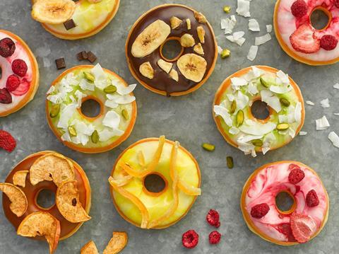 Colourful doughnuts with fruity toppings on a grey background