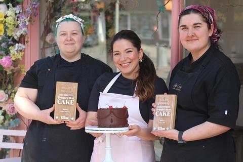 Abba Cakes - Founder Laura Alejandra (centre) showcases The Chocolate Cake with staff members holding Britain's Best Cake 2025 trophies -  2100x1400