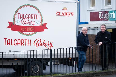 A truck with Talgarth Bakery branding on it with two smiling men stood next to it