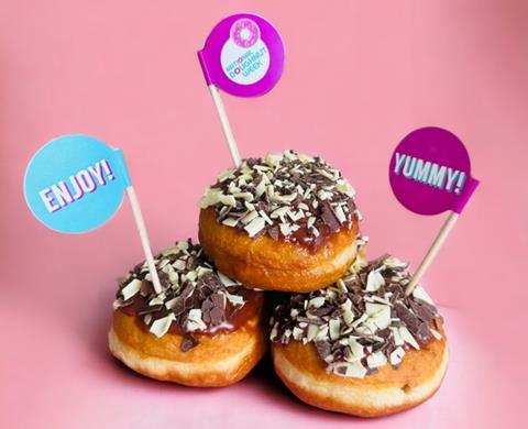 Three chocolate covered doughnuts with chocolate curls on top