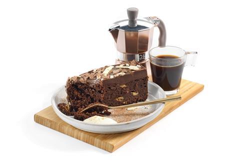A triple chocolate cake slice served with an espresso