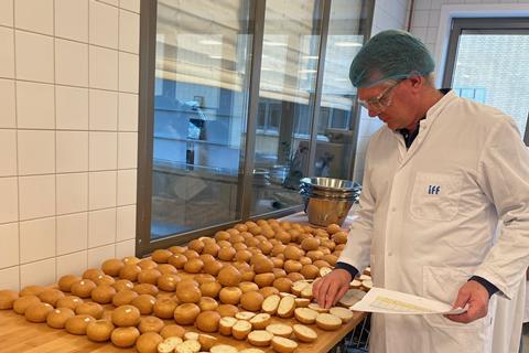 Gilbert van der Wal, in a white scientist's jacket, studying bread rolls