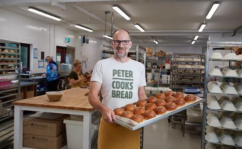 Peter Doughty-Cook in Peter Cooks Bread bakery holding a tray of buns