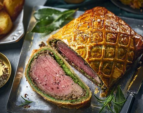 A beef wellington with a slice taken off to show the blushed meat inside