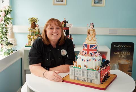 Johanna Moloney from Caketastic Creations next to a four tiered royal themed cake