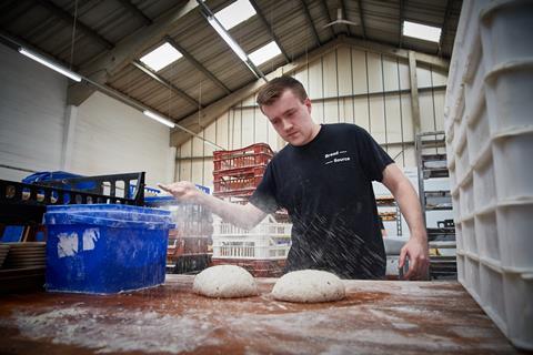 Jordan Skeet, a young baker sprinkling flour onto dough