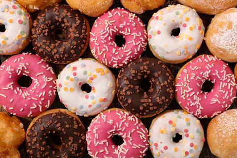 Ring doughnuts topped with chocolate, pink and white icing and sprinkles