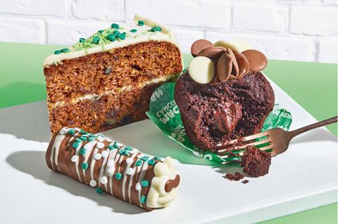 A slice of cake, chocolate muffin and mini caterpillar cake on a white plate