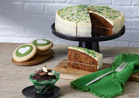 A sliced carrot cake, an iced biscuit, and chocolate muffin with green decorations
