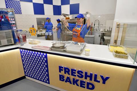 An Auntie Anne's staff member prepares a pretzel to be fresh baked at the Watford store  2100x1400