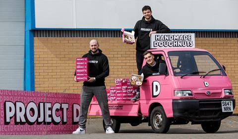 Three men with boxes of Project D doughnuts and a pink truck