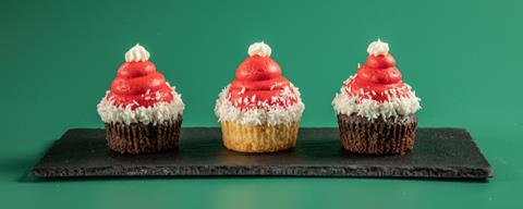 Christmas cupcakes with red frosting on top which looks like a Santa hat