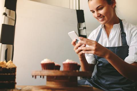 A woman taking a photo of cupcakes