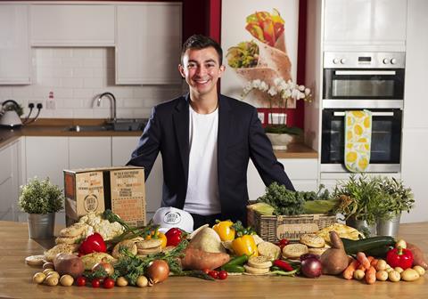 James Eid, founder of Earth & Wheat, in a kitchen with a pile of vegetables and baked goods