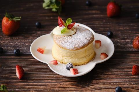 A soufflé pancake topped with a dollop of cream and a strawberry