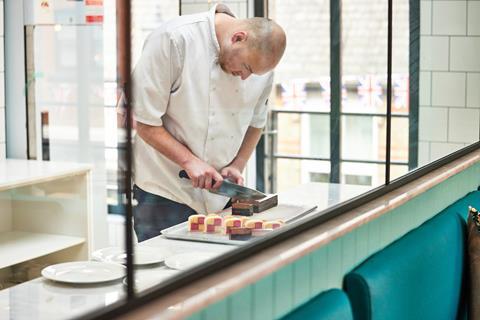 A chef cuts cake slices at the pastry kitchen of the Tea House at Bread Ahead's Chelsea bakery  2100x1400