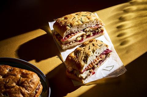 A focaccia filled with slices of turkey, stuffing, and cranberry sauce